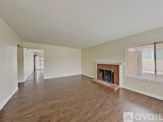 A spacious living room with a fireplace and hardwood floors.