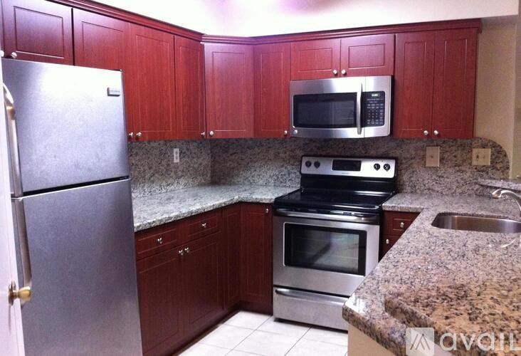 A kitchen with a granite counter top and stainless steel appliances.