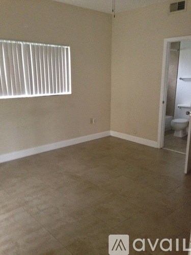 A room with a tile floor and a toilet in the corner.