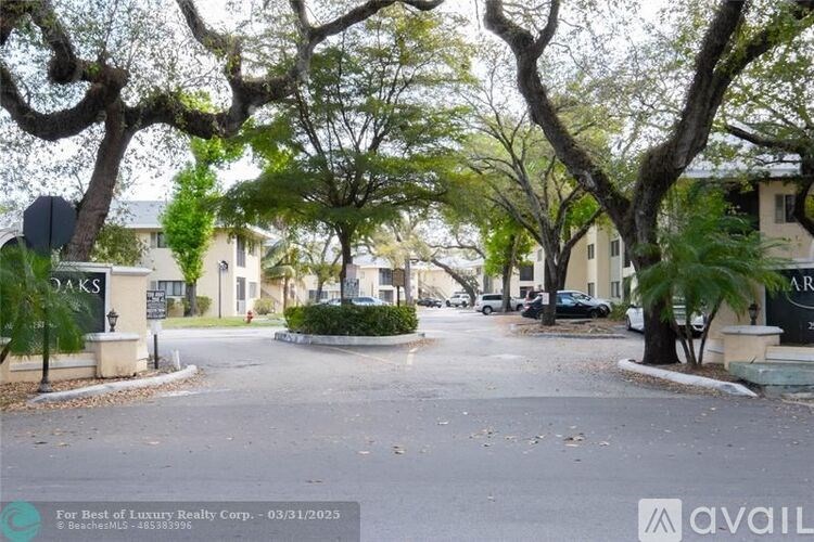 A street view of a residential area with a sign that reads "Oaks".