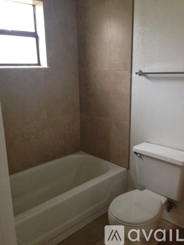 A bathroom with a toilet, tub, and towel rack.