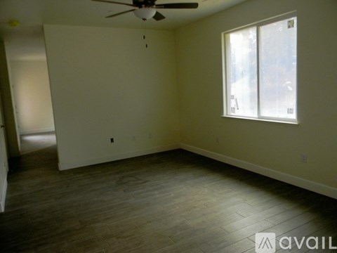 A room with a ceiling fan and a window.