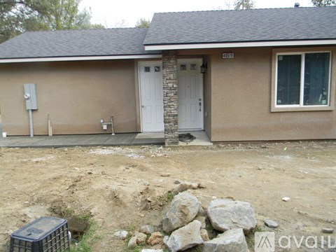 A house with a brown exterior and a white door is for sale.