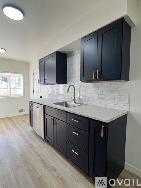 A kitchen with black cabinets and a white countertop.