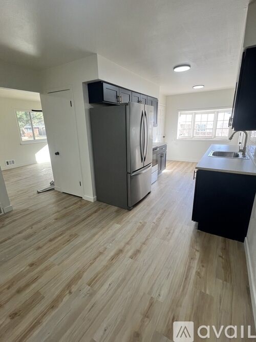 A kitchen with wooden floors and a black counter.