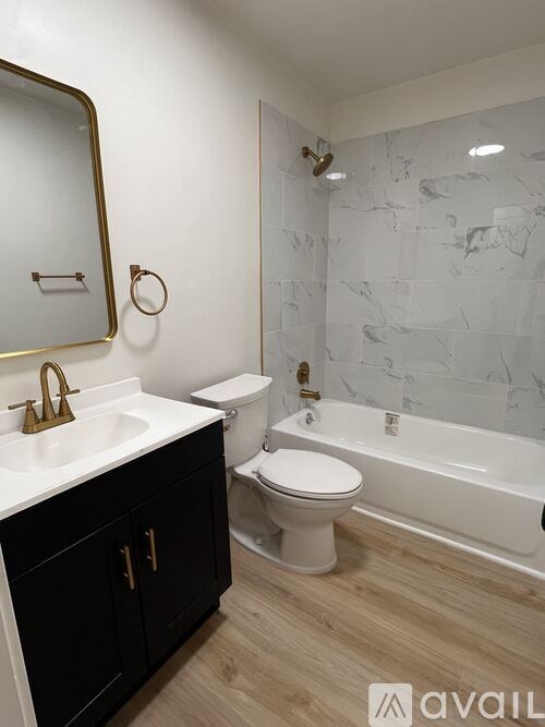 A bathroom with a marble wall and a white toilet.
