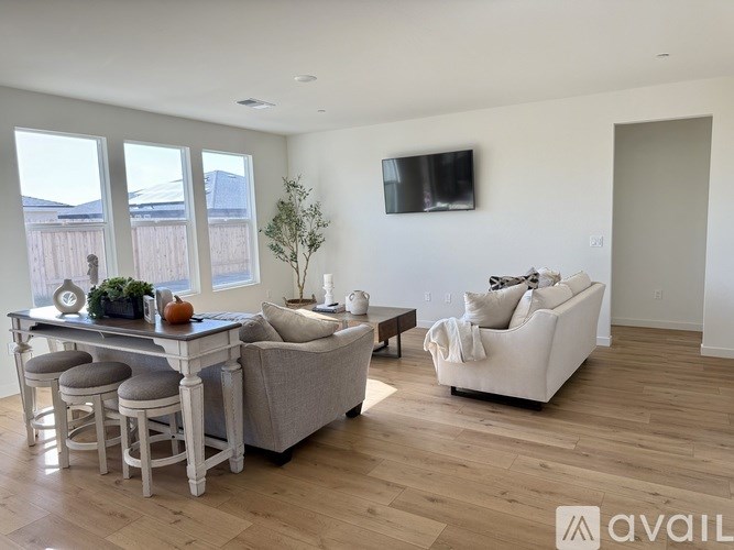 A living room with a white couch, a white table, and a white chair.