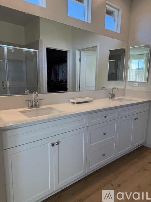 A bathroom with two sinks and a large mirror.