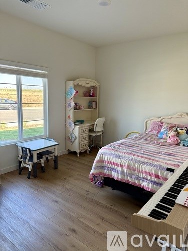 A bedroom with a bed, desk, and chair.