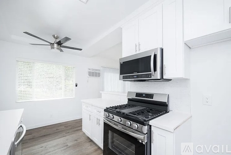 A kitchen with white cabinets and a black stove top oven.