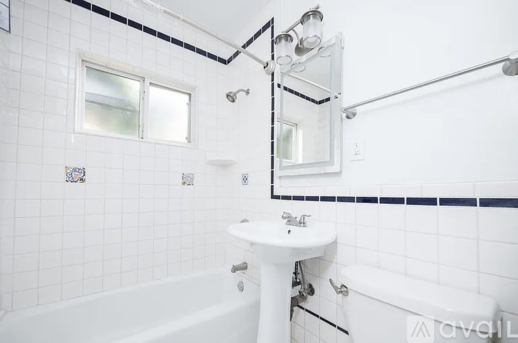 A white bathroom with a white tub, sink, and mirror.