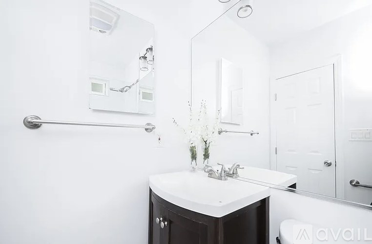 A bathroom with a white sink and a mirror.