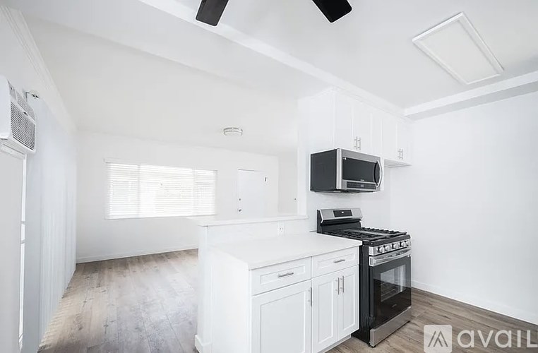 A kitchen with white cabinets and a black stove top oven.