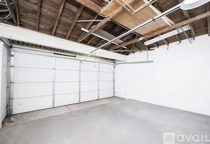 A large white garage door is closed and the garage is empty.