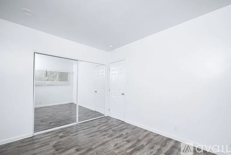 A room with a white wall and a wooden floor.