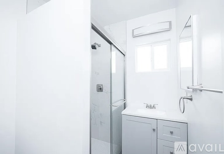 A white bathroom with a sink and mirror.