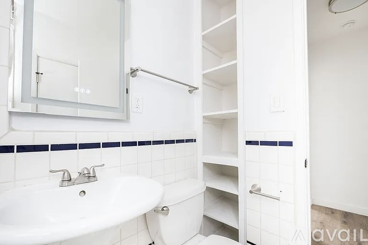 A white bathroom with a white sink and a white cabinet.