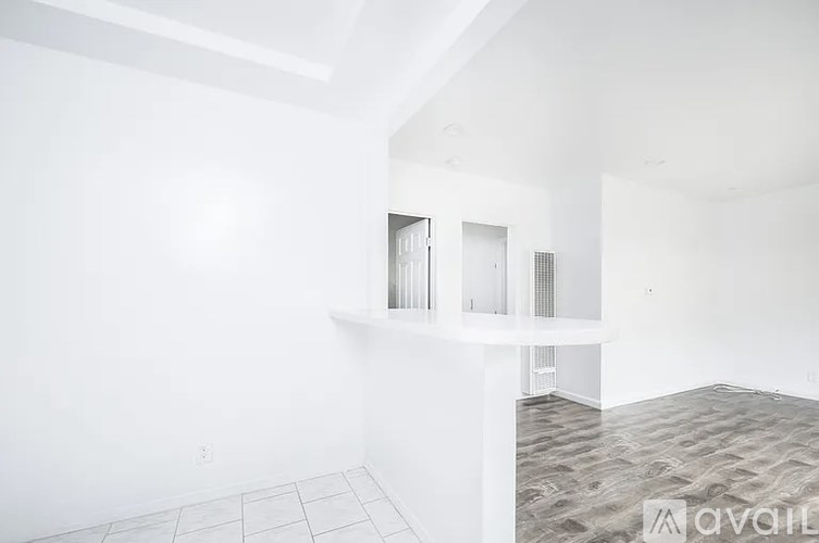 A room with a carpeted floor and a white wall with a window.