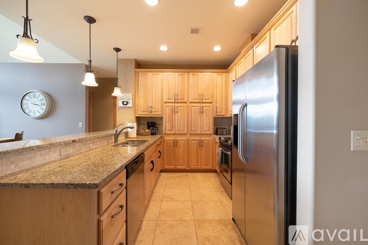 A kitchen with wooden cabinets and a granite countertop.