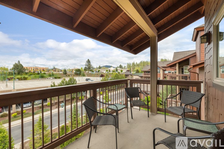 A balcony with chairs and a view of a street and buildings.