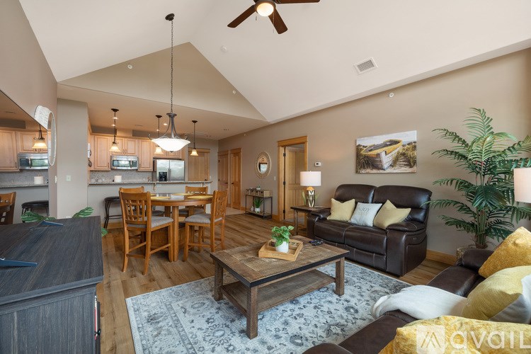 A living room with a couch, coffee table, and ceiling fan.