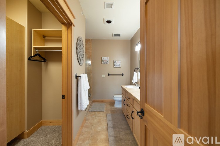 A bathroom with wooden cabinets and a towel hanging on the wall.