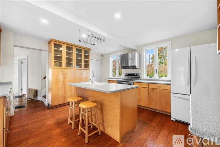 A kitchen with wooden floors and white appliances.