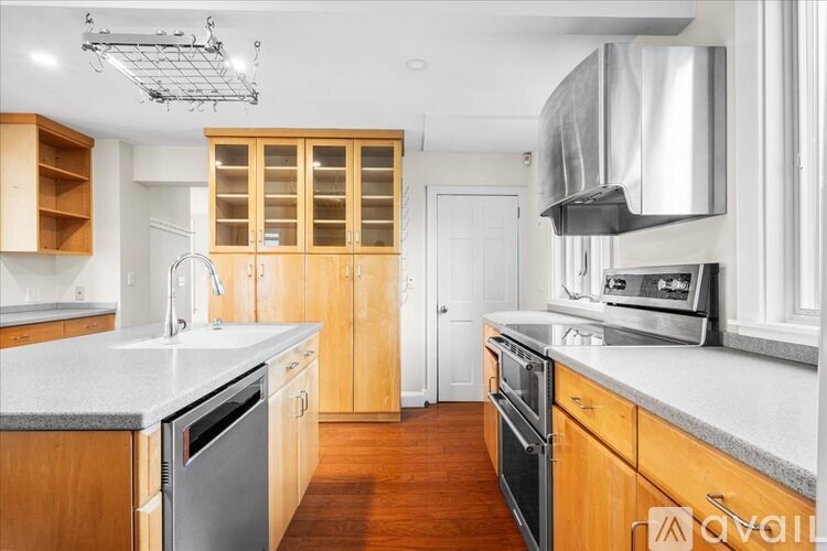 A kitchen with wooden cabinets and a stainless steel dishwasher.