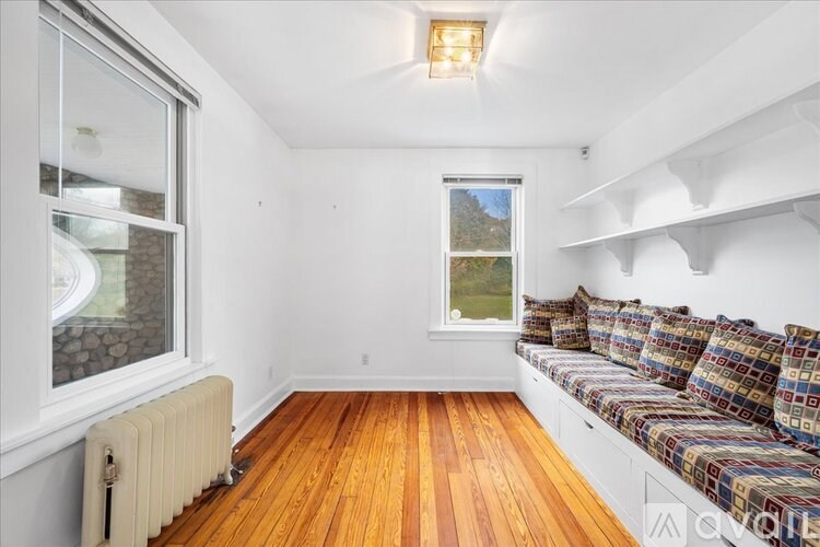 A room with a window and a radiator on the floor.