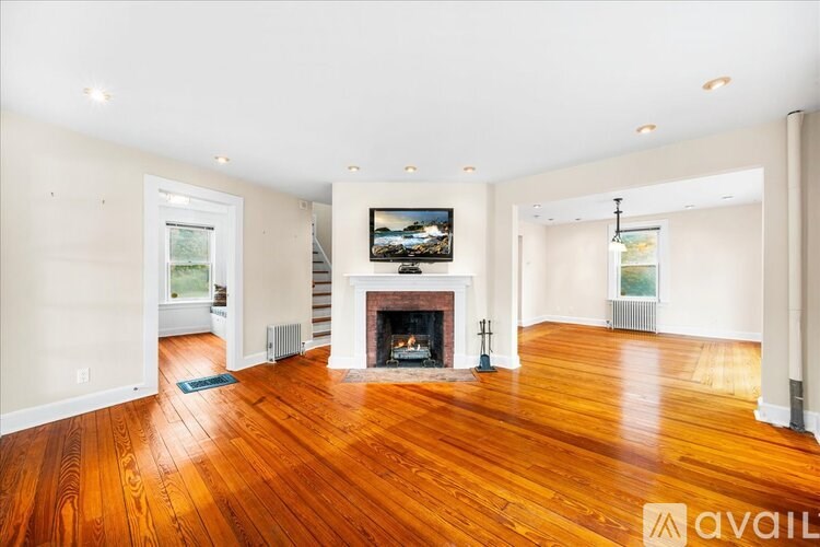 A living room with a fireplace and a painting on the wall.