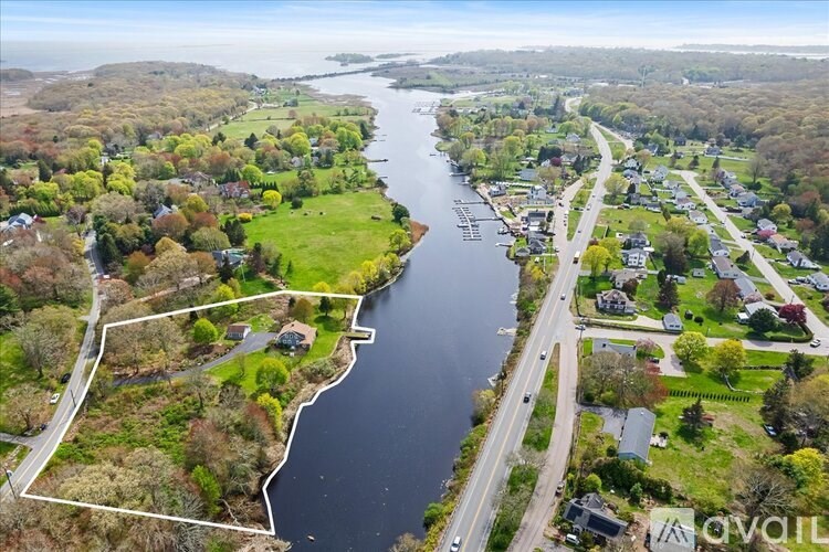 A river flows through a small town with a road running parallel to it.