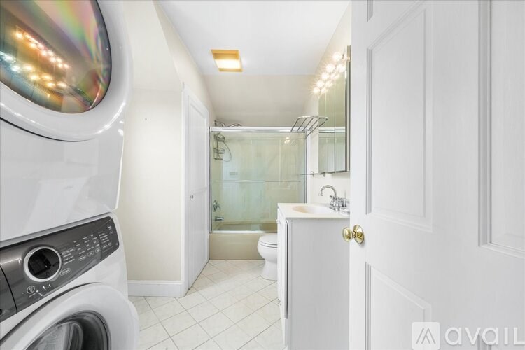 A white bathroom with a washer and dryer in it.