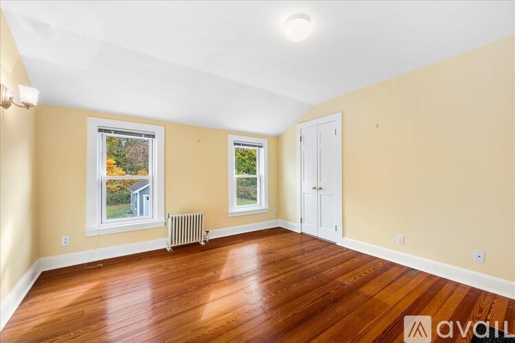 A room with wooden floors and two windows.
