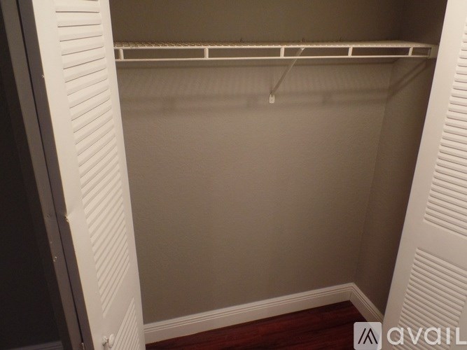A white closet with a shelf and a hanger.