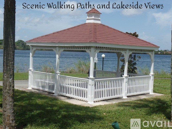 A gazebo is situated on a grassy area next to a lake.