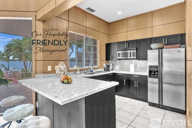 A modern kitchen with a marble island and stainless steel appliances.