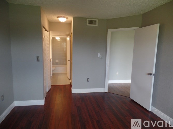 A hallway with wood floors and white walls.