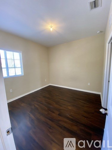 A room with wooden floors and a window.