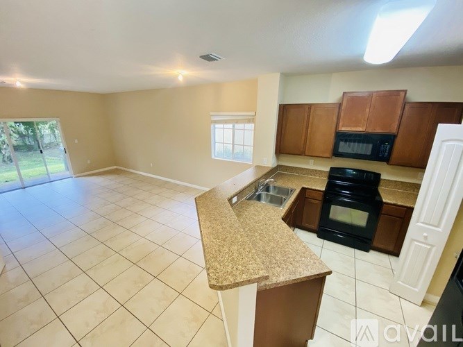A kitchen with a black oven and brown cabinets.