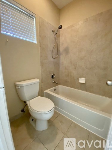 A bathroom with a toilet, tub, and shower.