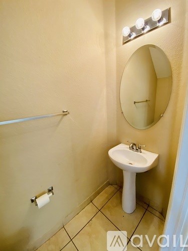 A bathroom with a sink, mirror, and lights.