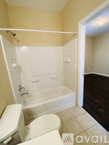 A bathroom with a toilet, tub, and shower.