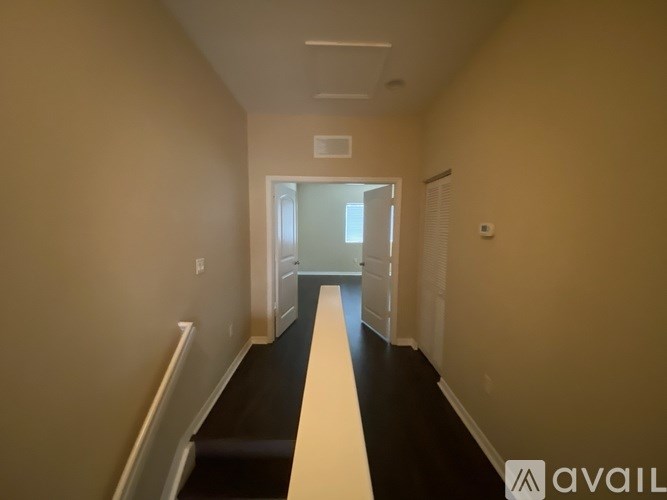 A long hallway with a white door at the end.