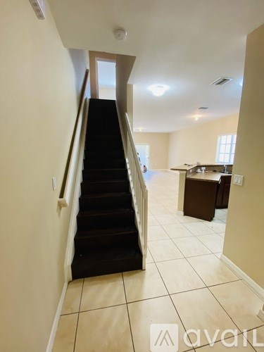 A hallway with a staircase leading to a second floor.