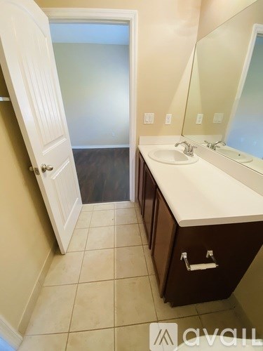 A bathroom with a sink, mirror, and a white door.