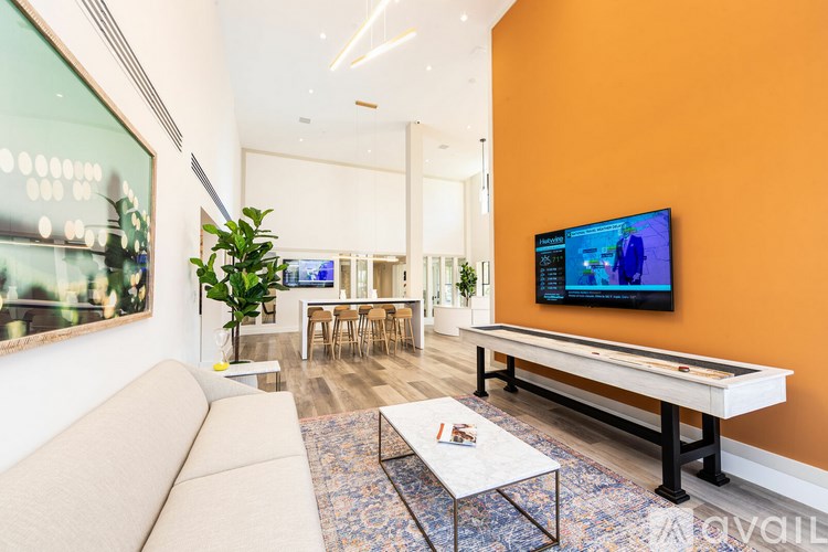 A living room with a pool table and a television.