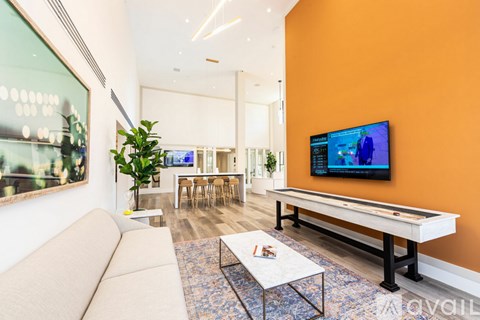 A living room with a pool table and a television.