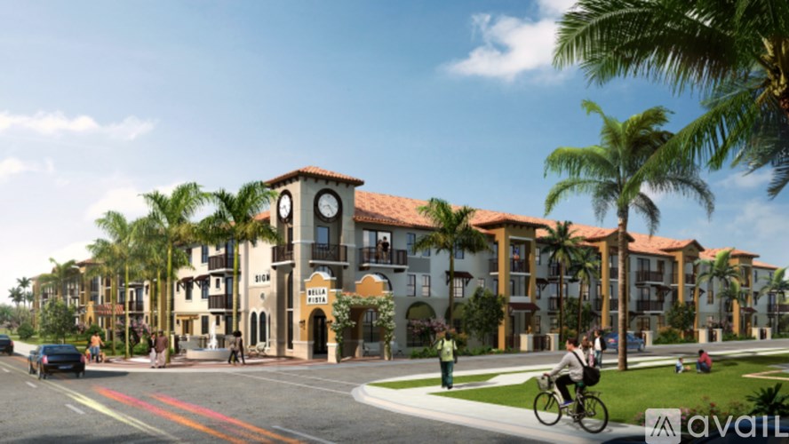 A street view of a residential area with a clock tower building and palm trees.