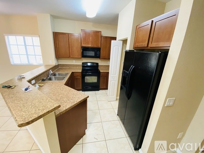 A kitchen with black appliances and wooden cabinets.