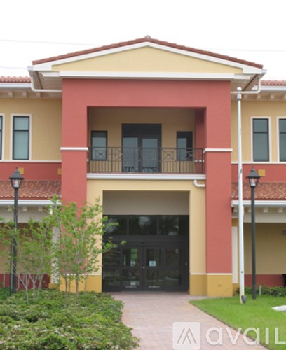 A building with a red and yellow facade and a balcony.